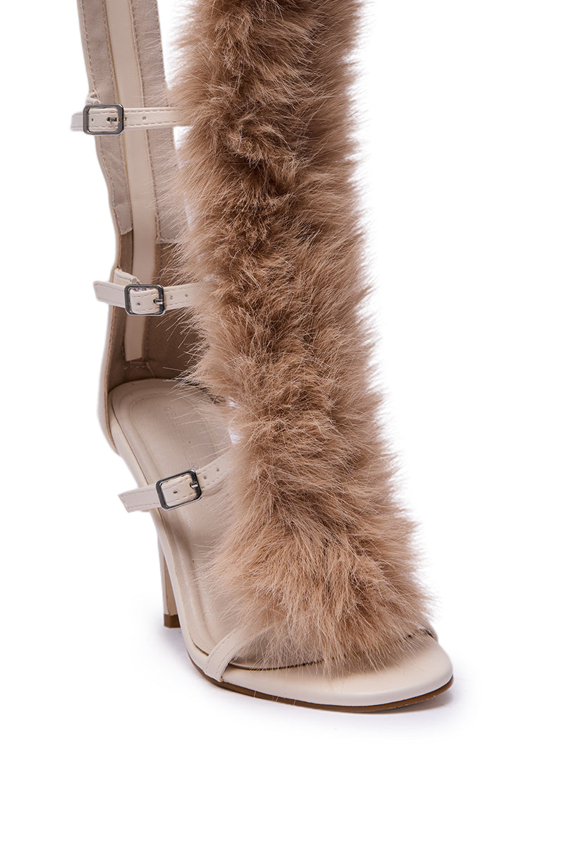The AZALEA WANG JUSTYCE IVORY FUR GLADIATOR SANDAL is a knee-high, high-heeled sandal with cream straps and buckles, featuring a bold vertical panel of fluffy brown faux fur running up the front for standout style.