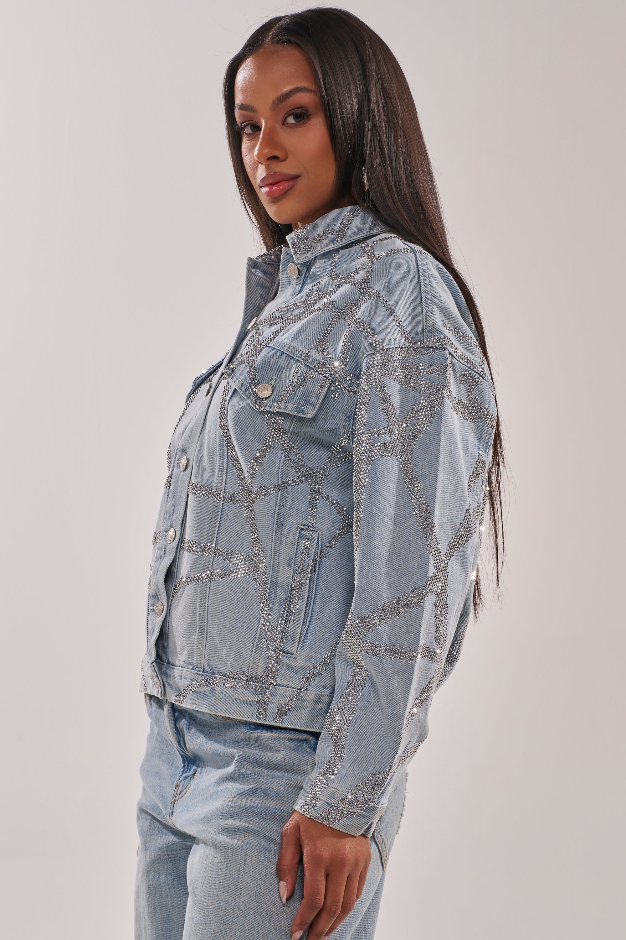 A woman with long straight hair wears the TWILIGHT ZONE RHINESTONE DENIM JACKET and matching jeans, posing against a plain light background. 5
