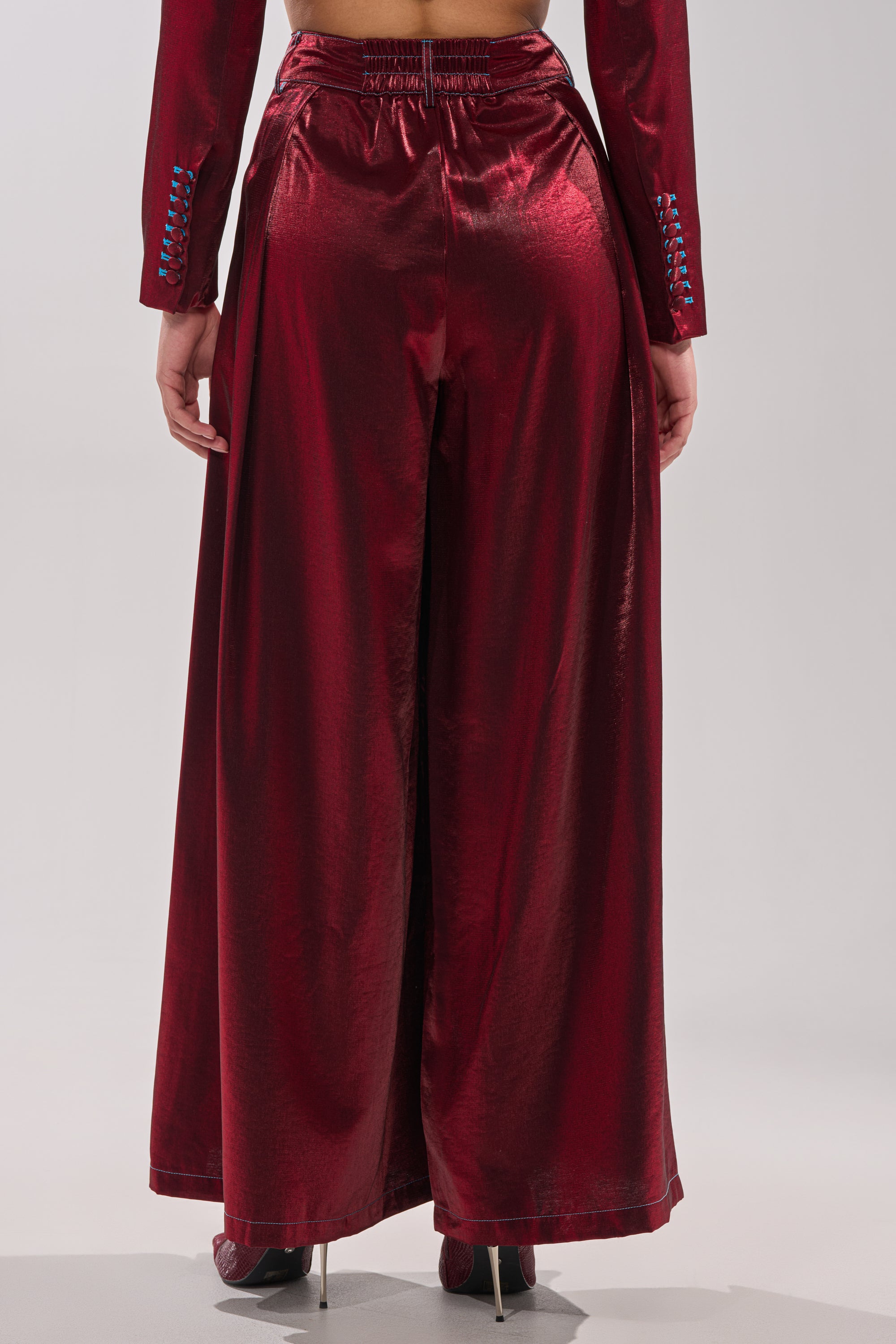 A person shown from the back wears the MISS YOU MOST WIDE LEG PANT in satin burgundy with a matching long-sleeve top, standing against a neutral background. 2
