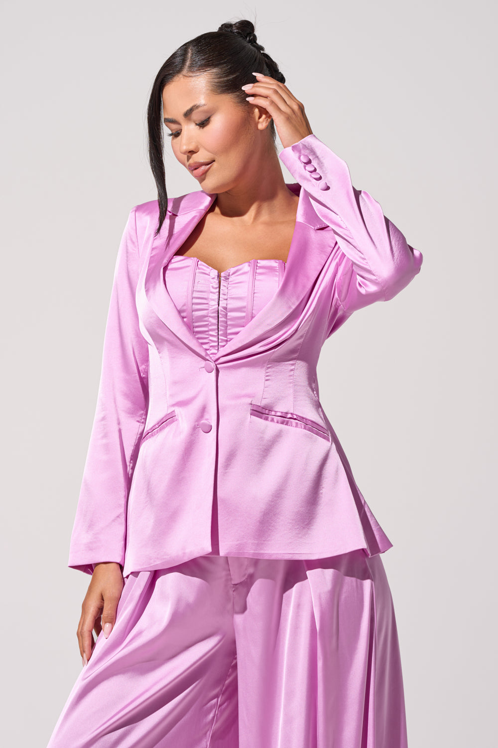 A woman in the IN FULL BLOOM LIGHT PURPLE BLAZER and wide-leg trousers stands against a plain light background, looking down with one hand touching her ear. 1