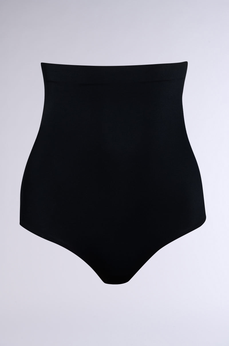 The TITSY SHAPER THONG IN BLACK sits on a simple white background, showcasing its smooth fabric and seamless hems, designed for support and contouring.