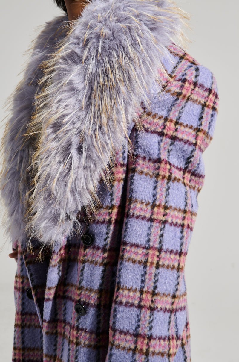 A close-up of the TEA FOR TWO FUR TRIM TRENCH showcases its plaid pattern, featuring a striking blue and pink checkered design complemented by black buttons. The coat's light brown fur trim adds a fluffy contrast, while the satin interior lining ensures comfort and elegance throughout the garment.