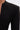 Close-up of a person wearing the WHEREVER YOU ARE CUTOUT TRENCH, a tailored black blazer with sharp shoulders and a deep V-neckline, styled like a longline coat, against a plain light background.