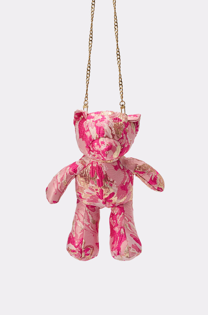 The REALLY ME BROCADE BEAR BAG is a small, pink and gold 3D bear-shaped purse with a gold chain strap, shown hanging against a plain light background. 4
