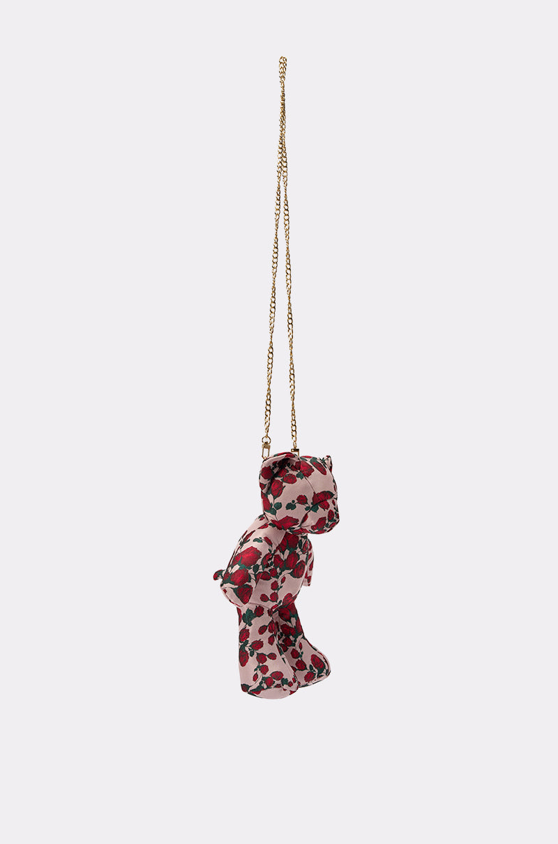 THE ONE ROSE BEAR BAG, a small teddy-shaped crossbody in a red and black floral pattern with a long gold chain strap, is displayed against a plain white background. 2
