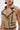 A person wears an EAST HAMPTON VEST IN BROWN with black trim, faux leather piping, gold accents, bold lapels, decorative black stripes, star-shaped earrings, and visible tattoos on the arm and chest.