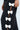 Close-up of someone in the FEELING CUTE BOW DETAIL PANT, showcasing its wide leg silhouette and high-rise waist. The black pant has a side slit with four white bows, with the person's hand resting near this stylish feature.