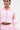A person wears the CANDY LACE TRIM WINDBREAKER, a light pink cropped jacket with puffy sheer sleeves and a white chest bow. They have facial piercings, hoop earrings, and a visible stomach tattoo.