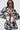 A woman in sunglasses and the PAINT THE ROSES RED JACQUARD BOMBER with black and white floral rose patterns, plus matching shorts with a number 2 and rose designs, poses confidently against a plain background, channeling a streetwear vibe.