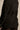 Close-up of the back of the CORTEZ PEPLUM BLAZER, showcasing its fitted design with a belted waist and buckle detail, paired with lacy black tights. The image highlights its tailored texture and modern silhouette.