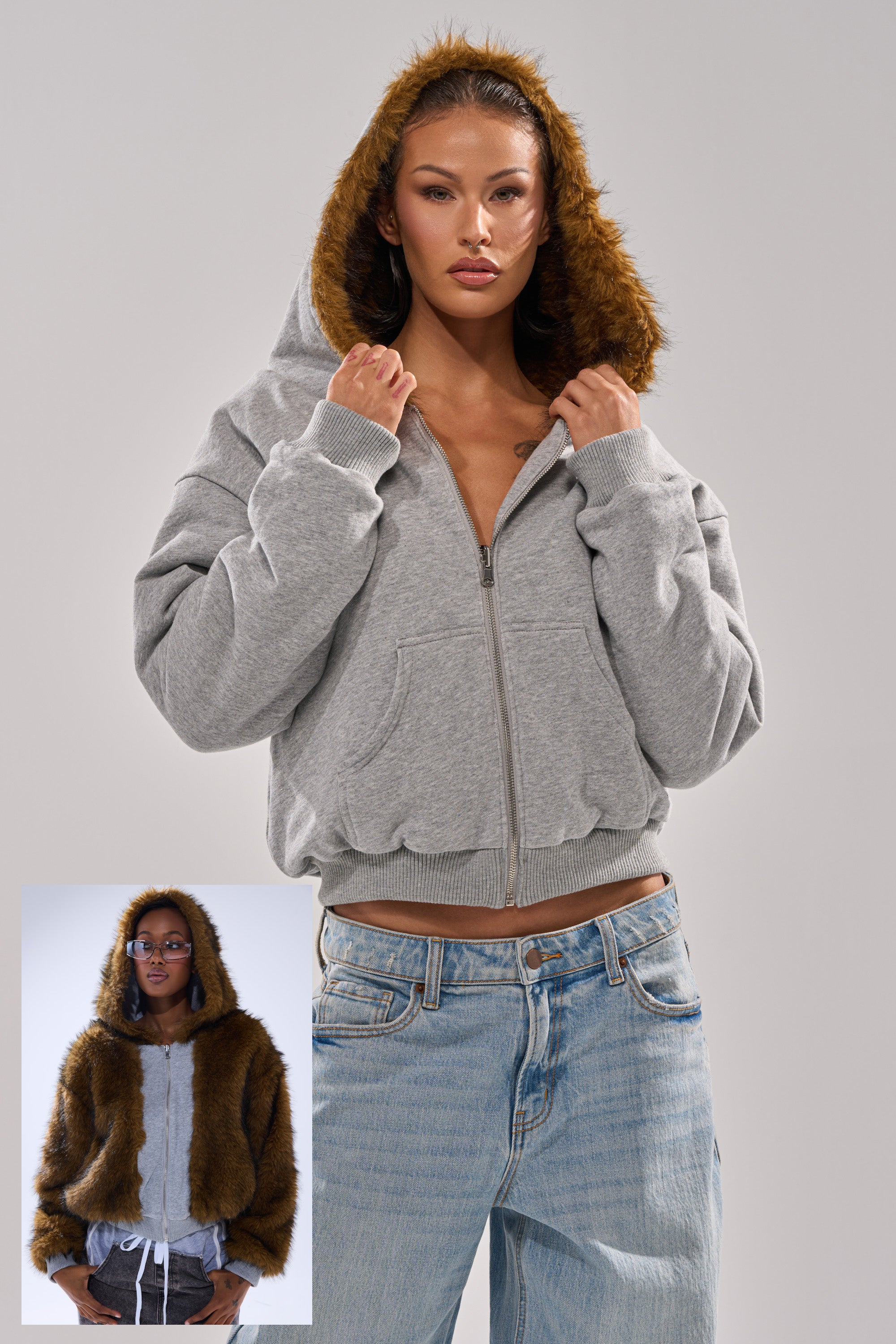 A woman wears the BEST OF BOTH WORLDS REVERSIBLE FUR SWEATSHIRT with its gray layered side and brown faux fur-lined hood, paired with light blue jeans; a smaller image shows her with the cozy fur side on display. 0