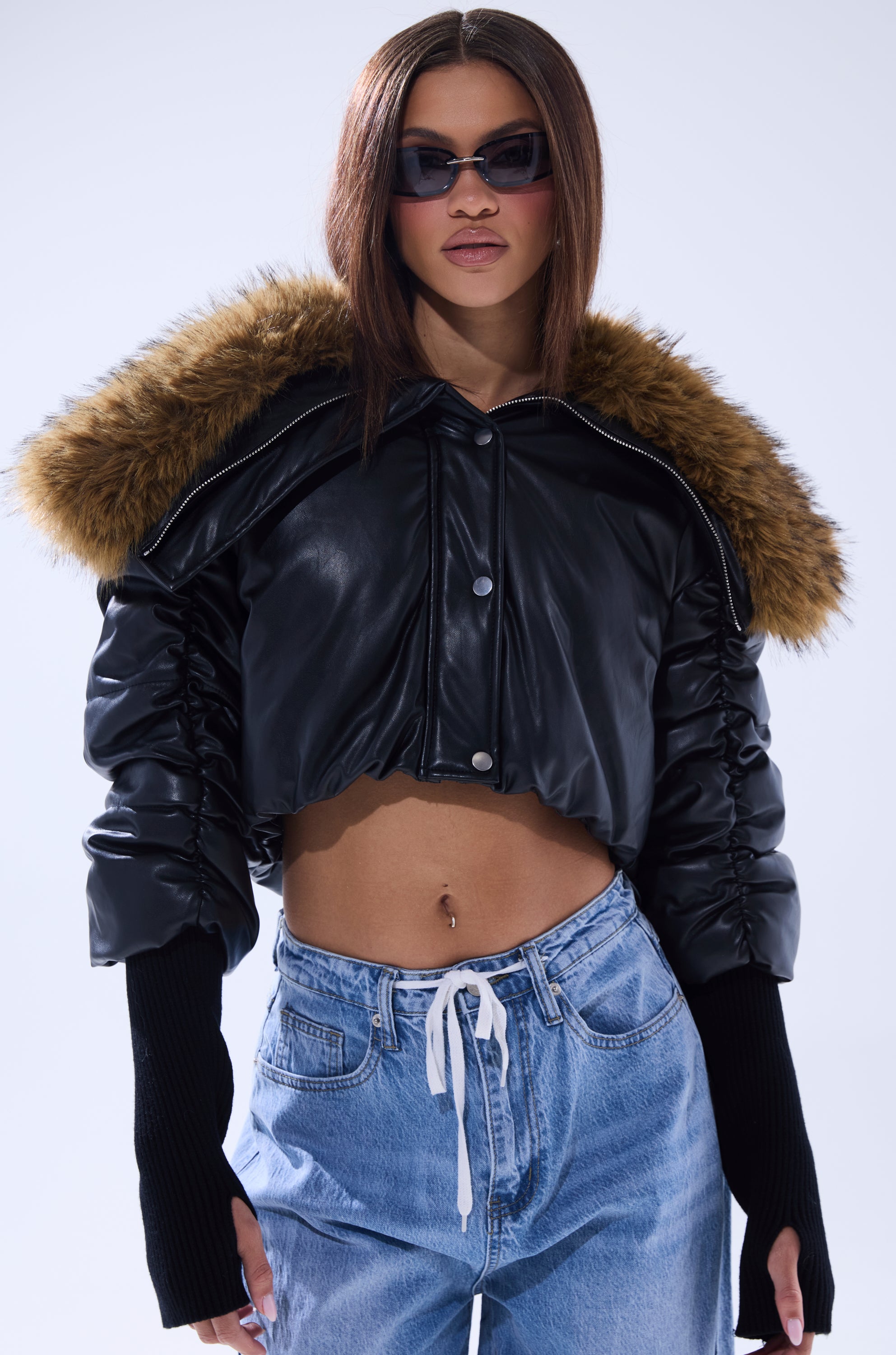 A woman in the KICKBACK FUR TRIM BOMBER, a chic faux leather jacket with stylish fur trim. 0