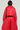 A person is wearing the VIVI Cropped Puffer Bomber in Red by AKIRA Label, styled with matching wide-legged pants. The diamond-quilted design, prominently displayed from the back, accentuates the outfit’s texture and structure against a neutral light gray backdrop.