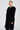 A person exudes confidence wearing the SASHA FIERCE LONG FUR TRIM CARDIGAN, draped over a chic oversized relaxed fit outfit. They accessorize with a striking necklace and hoop earrings, complementing their sleek hairstyle, all set against a plain background that highlights their fashionable attire.