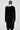 A person with their hair in a bun is wearing the oversized SASHA FIERCE LONG FUR TRIM CARDIGAN, featuring faux fur trim along the edges. They are facing away from the camera, highlighting the cardigan's back against a plain, light-colored background.