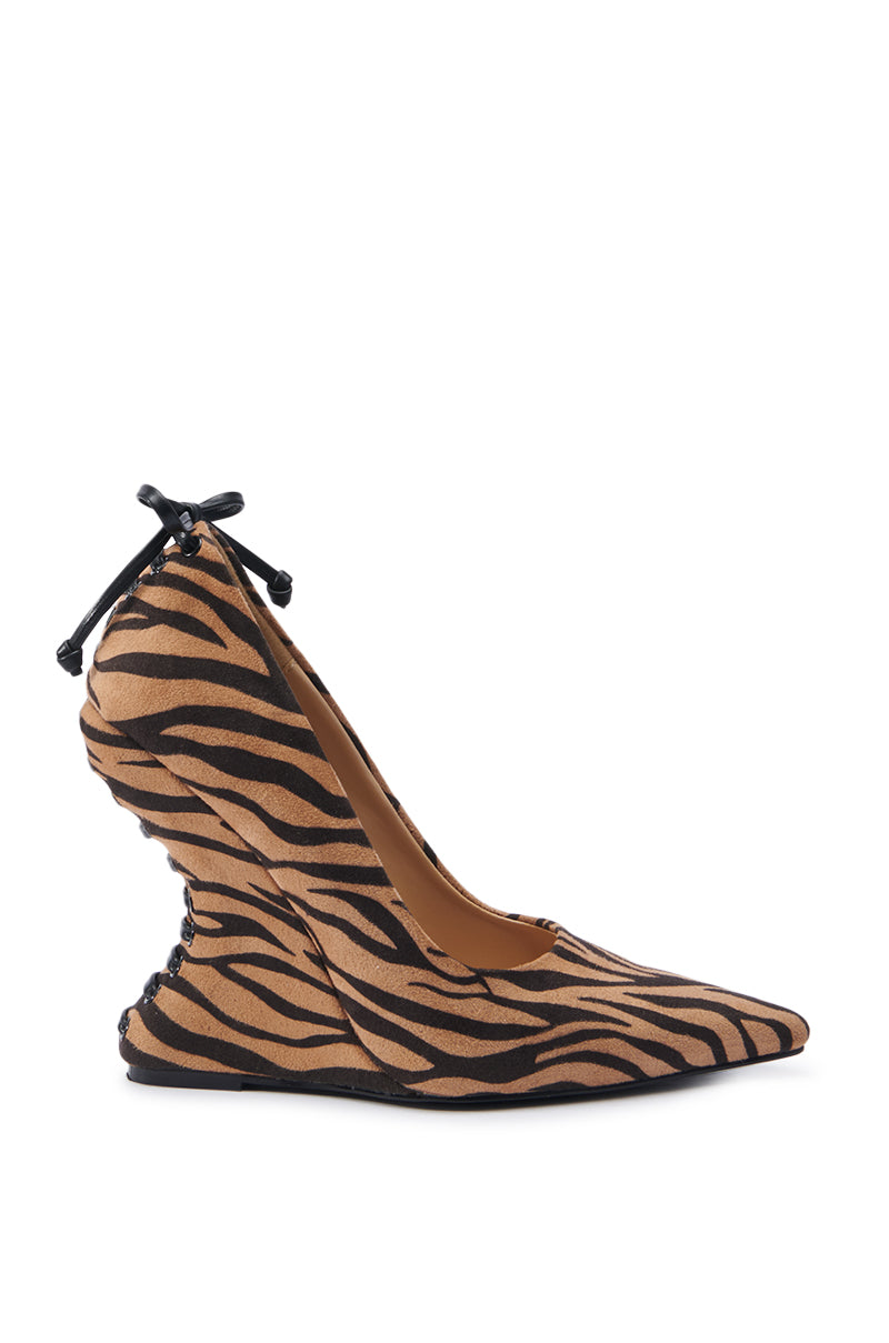 The AZALEA WANG KABIRA MULTI WEDGE PUMP showcases a unique wavy heel design combined with an eye-catching brown and black tiger print pattern. A small bow decorates the back for added flair. Made from faux suede, this shoe features a pointed toe and exudes a sleek, stylish look.