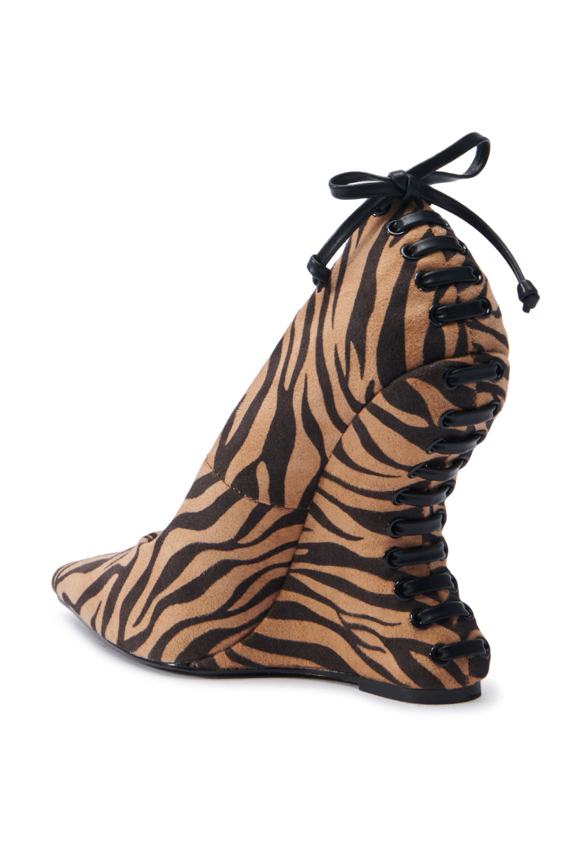 Introducing the AZALEA WANG KABIRA MULTI WEDGE PUMP: This stunning shoe showcases a bold zebra pattern with black lace-up detailing at the back. Made from faux suede, it features a pointed toe and high heel, effortlessly combining animal print with unique lacing to create a striking fashion statement.