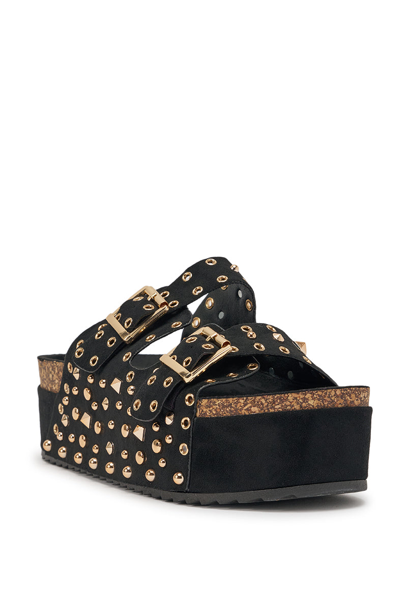 The AZALEA WANG KAEGAN Black Flatform Stud Embellished Slip On Sandal features two gold-buckled straps with gold studs and eyelets, and a thick cork and black sole. The studded sandal is angled to show the front and side views. 4