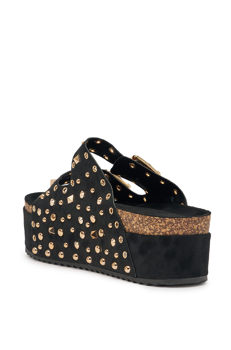 The AZALEA WANG KAEGAN Black Flatform Stud Embellished Slip On Sandal, with gold studs, suede finish, cork-style midsole, and crisscross straps, is shown from the back and side against a white background. 5