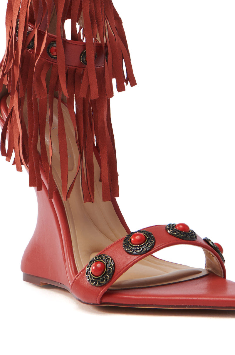 Discover the AZALEA WANG KALILA RED FRINGE SANDAL: a chic faux leather sandal in red, with a low wedge heel, ankle fringe, and gemstone-embellished straps that elegantly blend style and flair.
