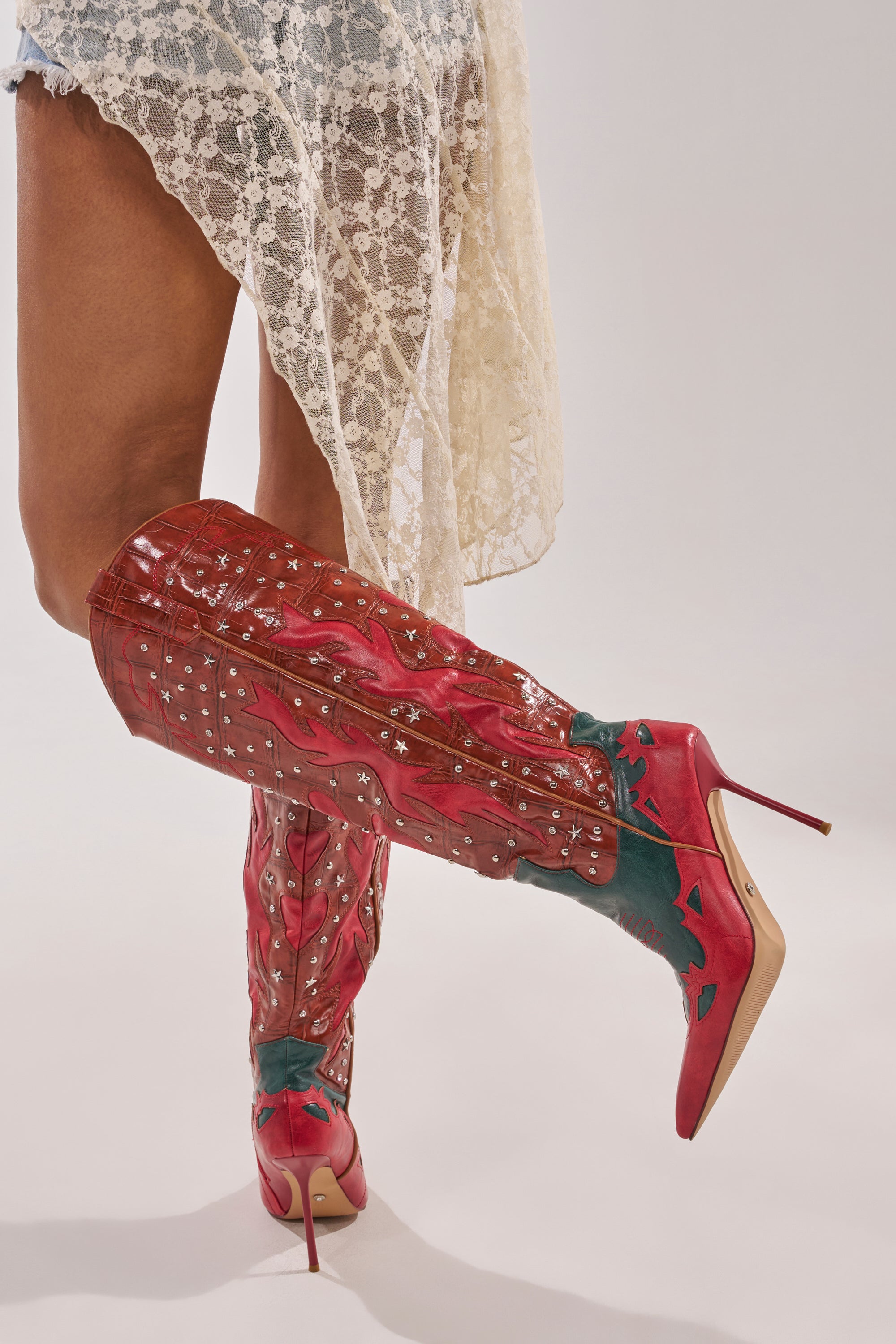 Wearing a short, lacey white dress and striking AZALEA WANG KALPANAS MULTI WESTERN STILETTO BOOT with decorative patterns and high heels, a person poses confidently against a plain background. 2