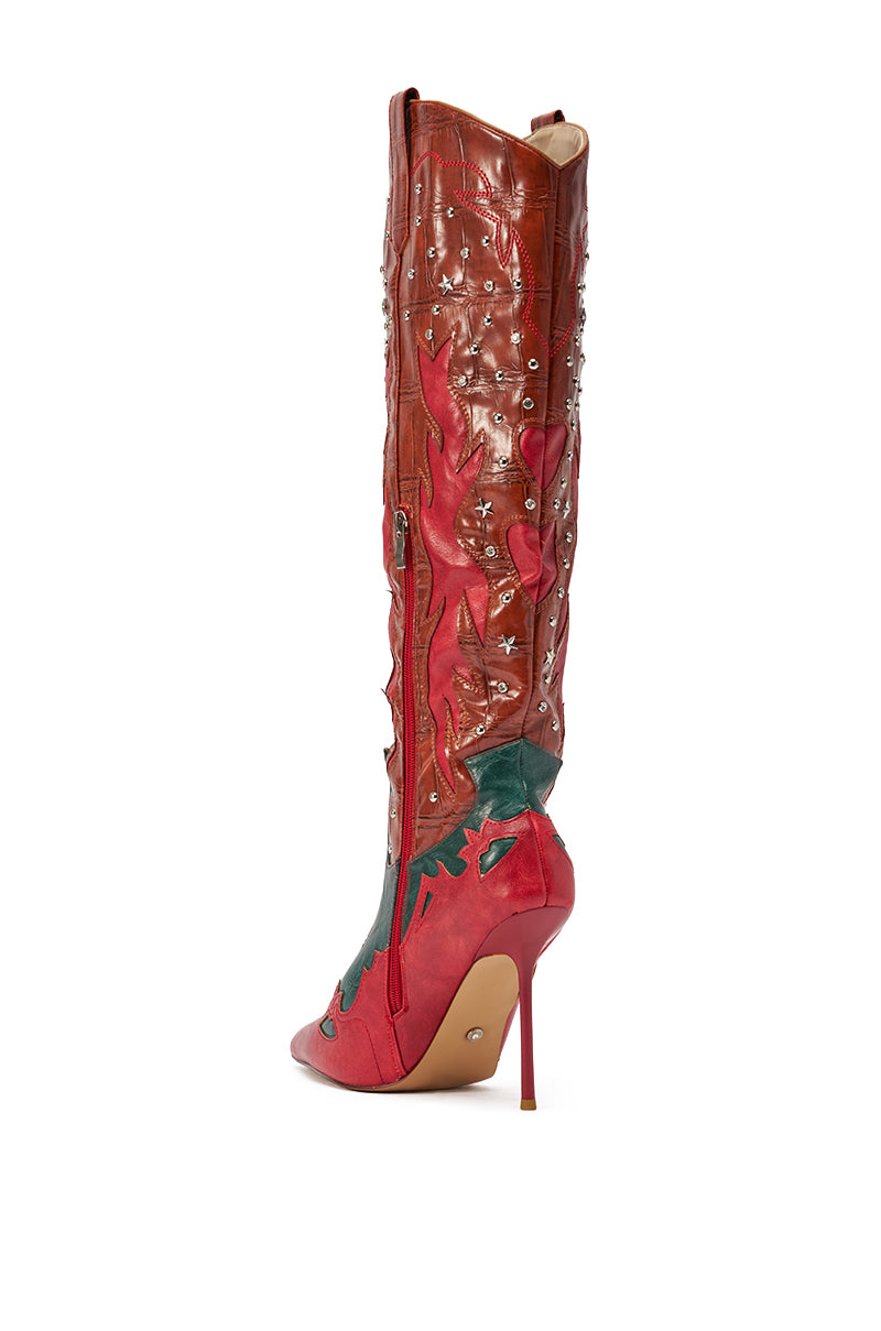 The AZALEA WANG KALPANAS MULTI WESTERN STILETTO BOOT features a tall, knee-high silhouette, pointed toe, red and brown faux leather in a cowgirl style with decorative stitching, silver star studs, and green leafy accents shown in a side view. 5