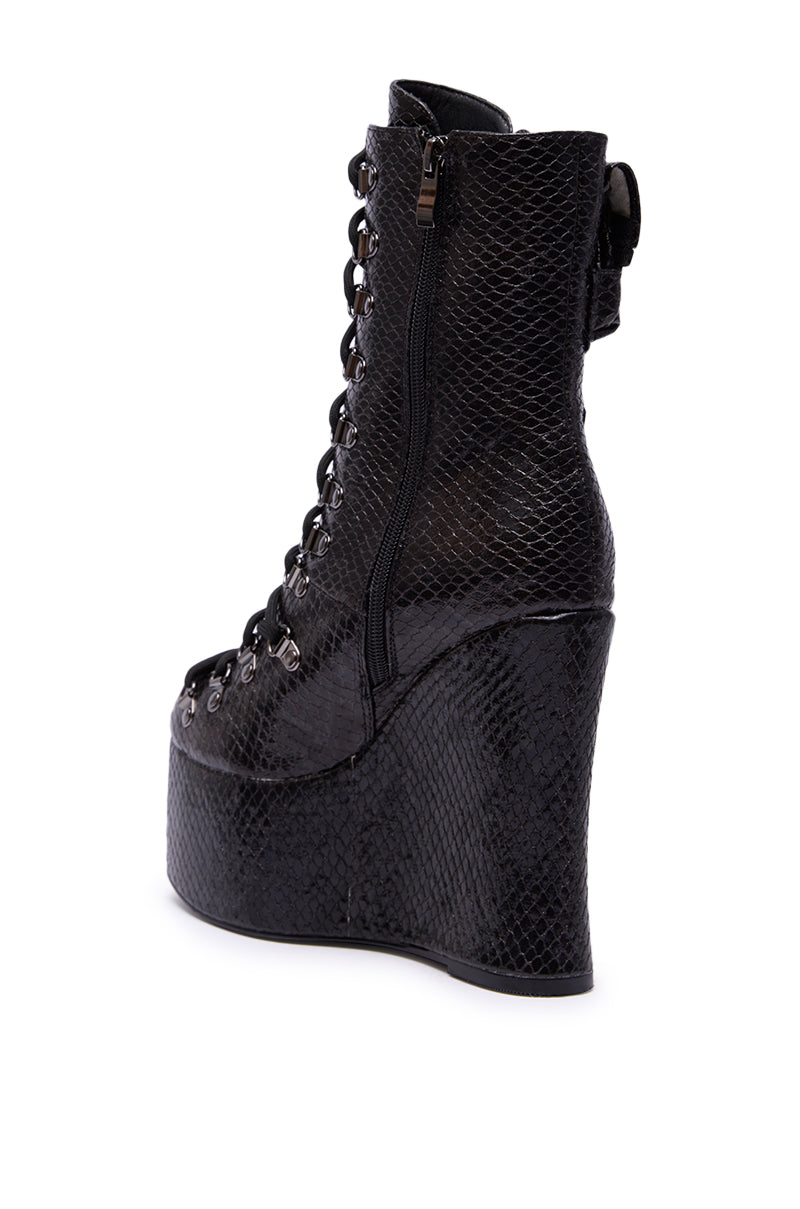 The AZALEA WANG KAPULE BLACK SNAKE PLATFORM BOOTIE features a black snakeskin texture, wedge heel, lace-up front, side zipper, and open toe. Shown from the back and side on a white background.
