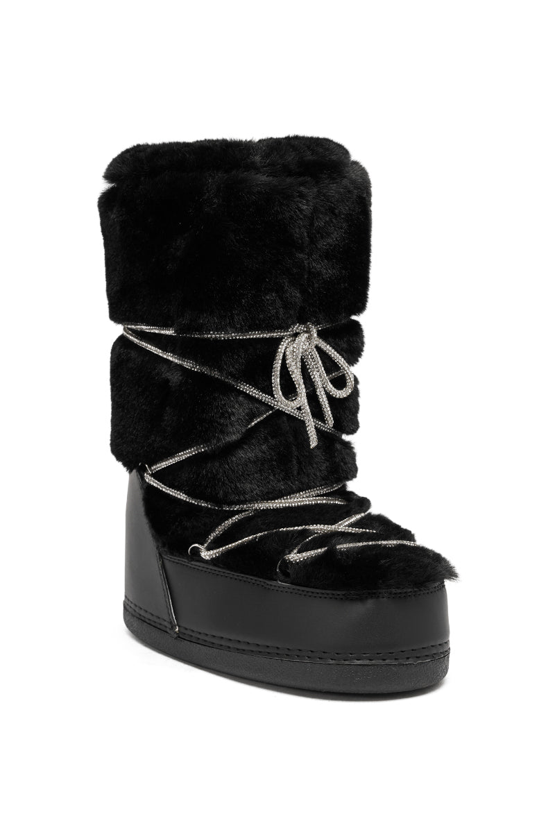 The AZALEA WANG KARMELA BLACK FUR MOON BOOT features a thick black faux fur exterior, decorative silver crisscross laces, and a flat sturdy sole—delivering standout winter style and cozy warmth.