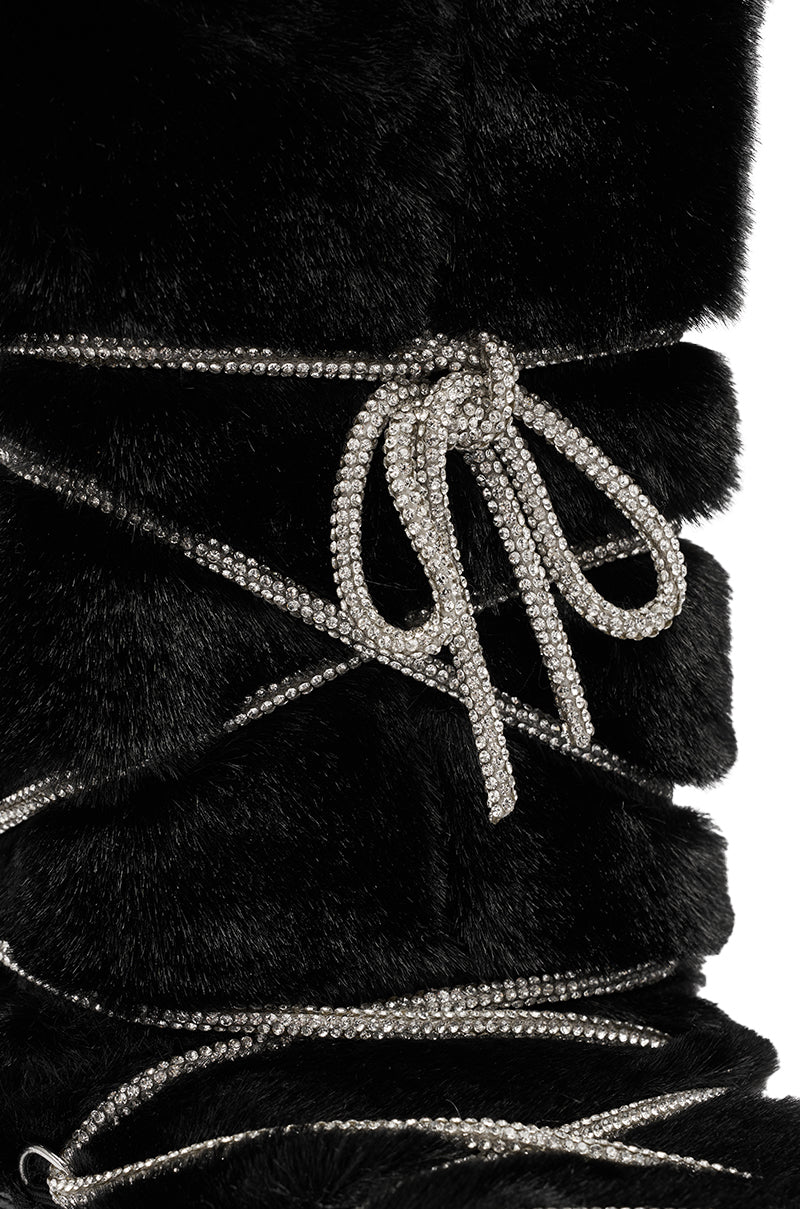 Close-up of the AZALEA WANG KARMELA BLACK FUR MOON BOOT featuring black fur and sparkling rhinestone laces wrapped multiple times and tied in a bow—perfect for chic faux fur winter boot style.