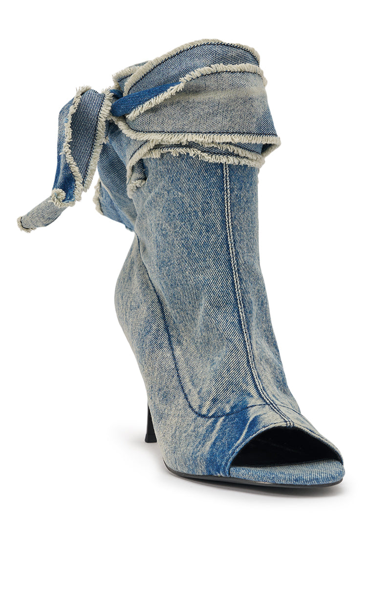 The AZALEA WANG KARTER DENIM OPEN TOE BOOTIE is a high-heeled bootie made from distressed blue denim, featuring frayed edges and a large side bow detail. 5