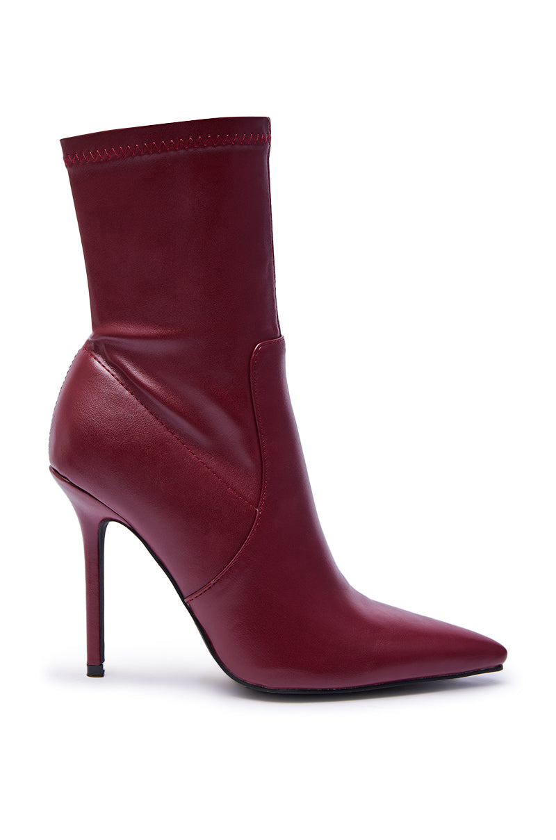 The AZALEA WANG KATHII BURGUNDY BOOTIE features a pointed toe, stiletto heel, smooth faux leather construction, and a sleek, fitted silhouette.