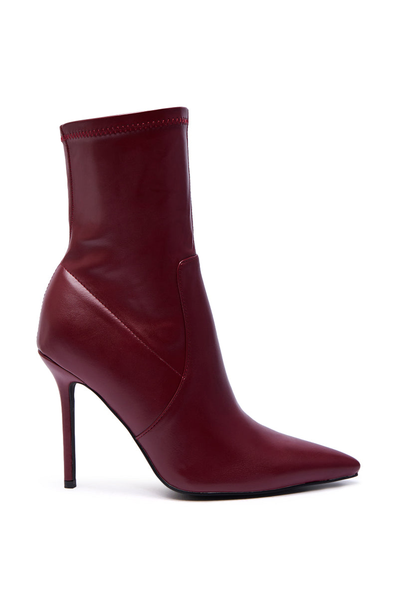The AZALEA WANG KATHII BURGUNDY BOOTIE features a sleek, pointed toe and slim stiletto heel, crafted from smooth, glossy burgundy faux leather for a bold, modern look.
