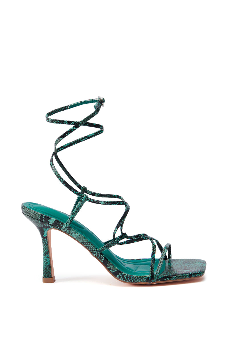 Introducing the AZALEA WANG KAYLIN GREEN SNAKE SANDAL: This high-heeled sandal features a bold green snakeskin pattern, a strappy design, and wrap-around ankle lace detail. The slender stiletto heel enhances its elegant and stylish appearance.