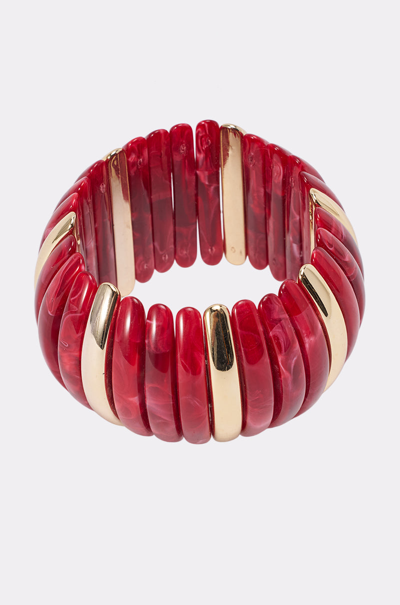 The DISC BRACELET IN RED features glossy, marbled red segments that alternate with gold-toned pieces for a bold, chunky metallic stretch design—creating a wide, eye-catching and comfortable statement cuff.