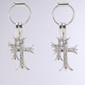 The CROSS CHARM EARRING features two silver metallic hoops with cross charms encrusted with rhinestone crystals, set against a plain gray background.
