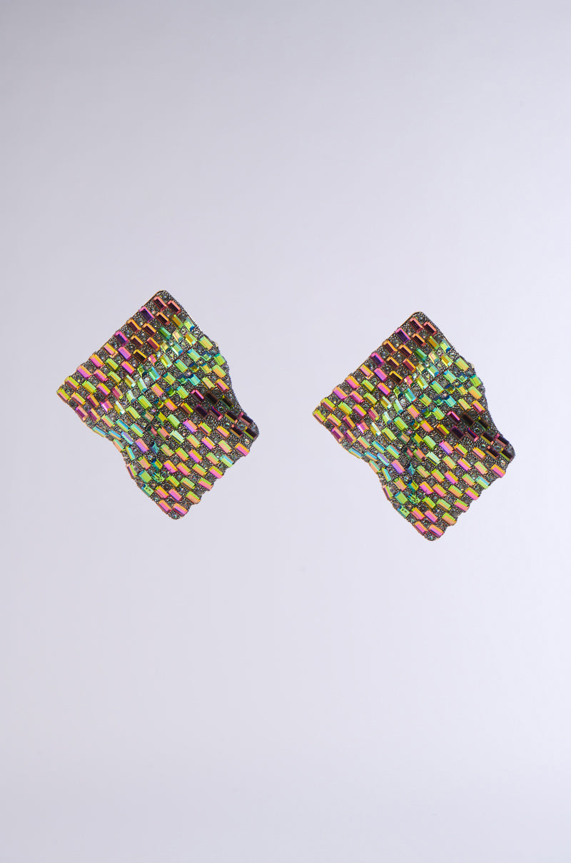 The SHINE BRIGHT EARRING features a diamond-shaped, textured design with a vibrant woven pattern in yellow, green, pink, and blue, resembling oversized earrings with a glossy finish on a plain light gray background. 0