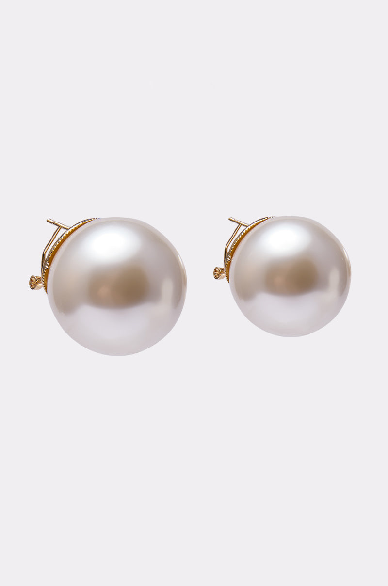 The TIFF EARRING is a pair of gold-tone statement earrings with large, round white pearls, showcased on a plain light gray background.