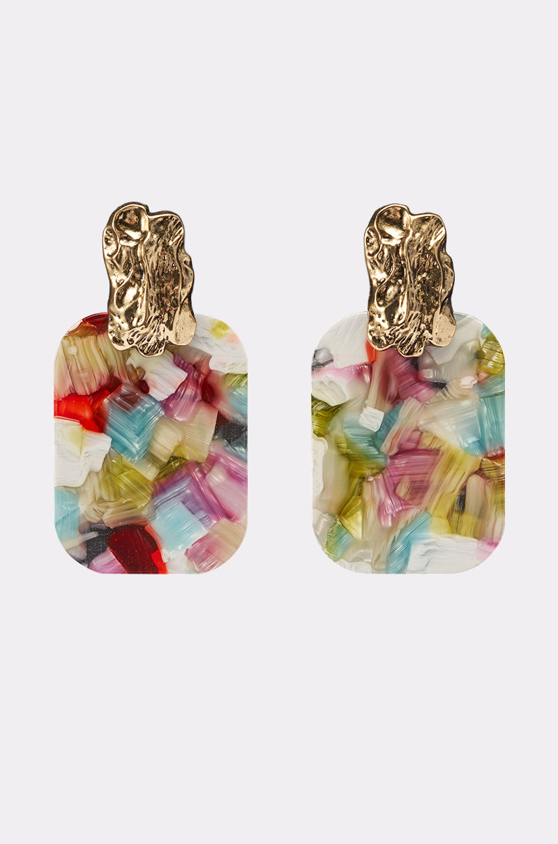 The AT A RESORT EARRING features rectangular statement earrings with gold textured studs and multicolor marbled drops in shades of red, pink, blue, yellow, and white, shown against a simple light background. 1