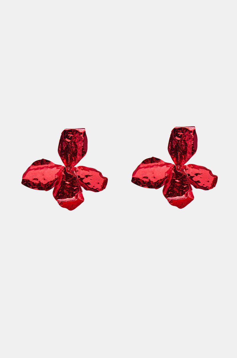 The HOLIDAY FEVER EARRING features shiny metallic red, three-petaled flowers in an oversized design, displayed against a plain white background.