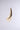The IN THE WIND EARRING, featuring a smooth gold-tone finish and an elongated abstract teardrop silhouette, is displayed against a plain light gray background.