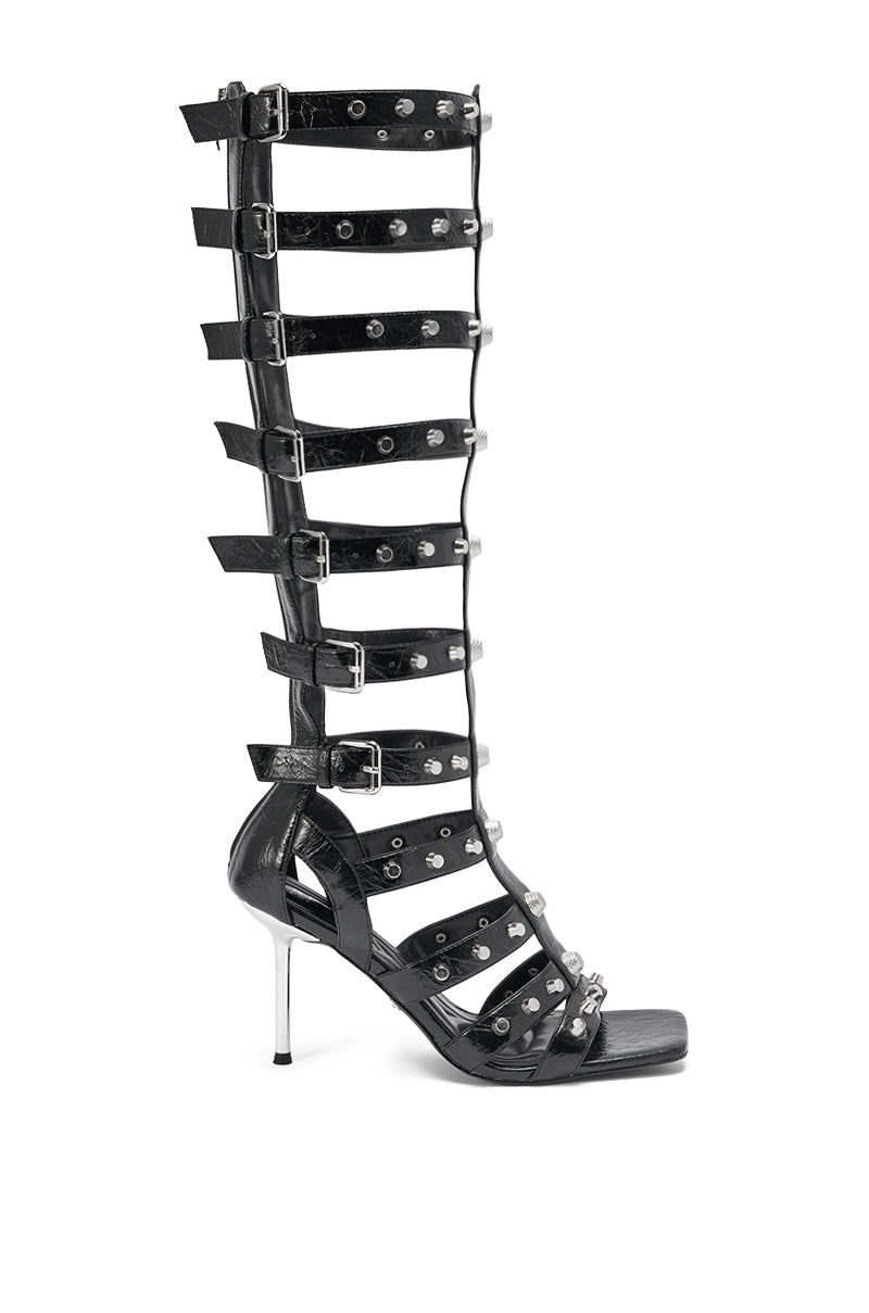 The AKIRA GOLD HARDWARE EMBELLISHED BLACK GLADIATOR SANDAL is a knee-high style with multiple straps, gold hardware, metal embellishments, an open toe, and a sleek stiletto heel in black. 3