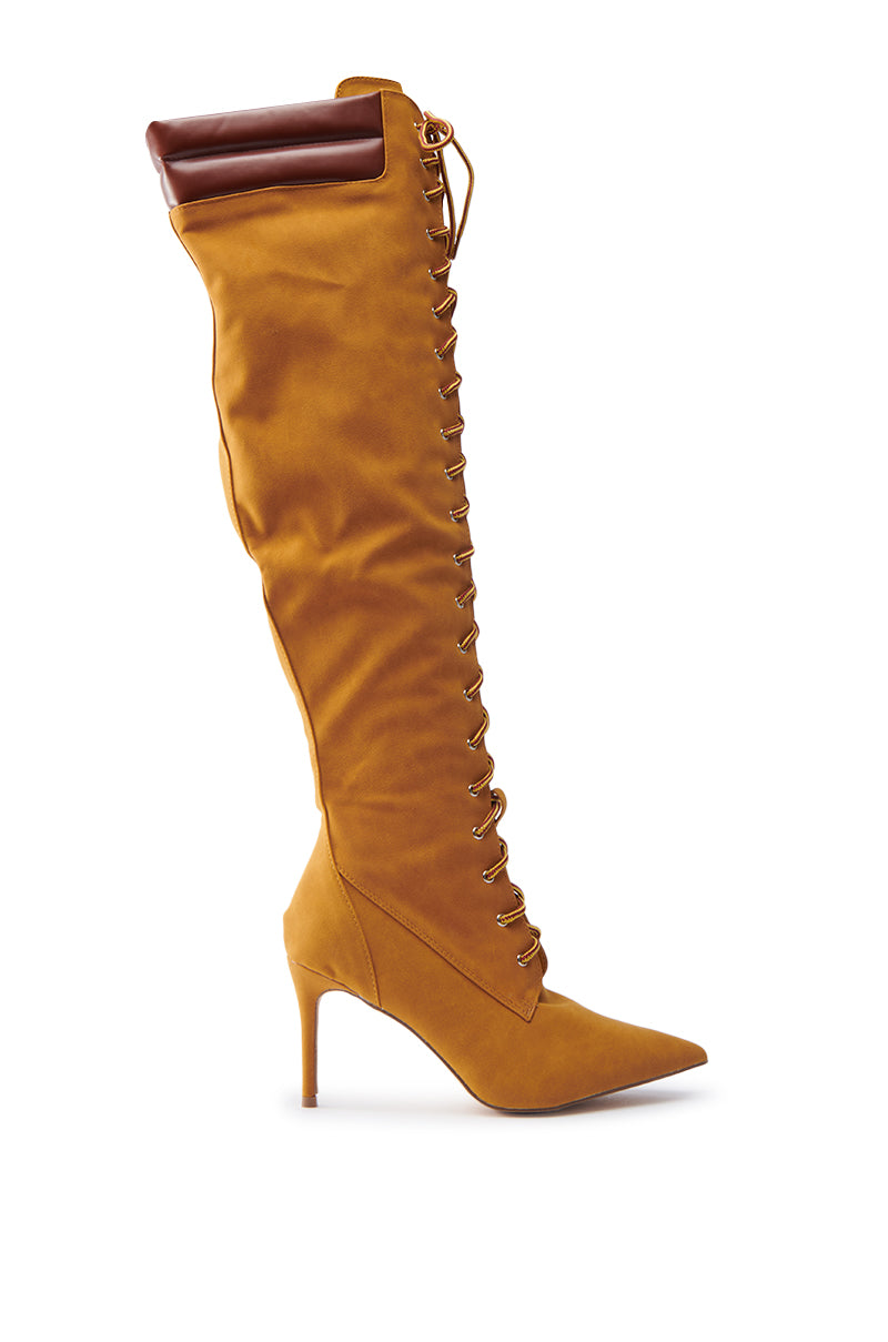 The KENDRIX SUEDE KNEE-HIGH BOOT features a brown faux suede design with a stiletto heel, lace-up front, pointed toe, and a leather-like cuff at the top.