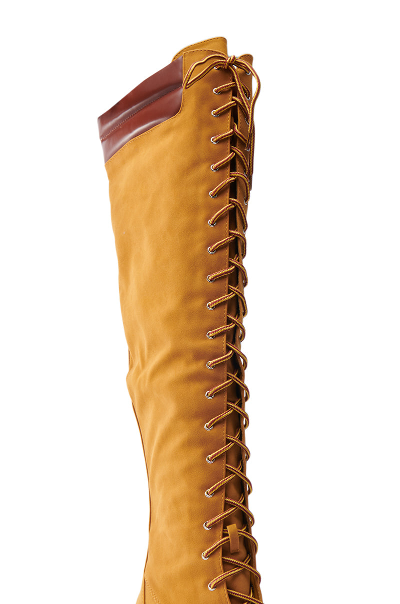 Close-up of the KENDRIX SUEDE KNEE-HIGH BOOT showcasing tan faux suede with brown leather trim at the top and a detailed lace-up design on the side.