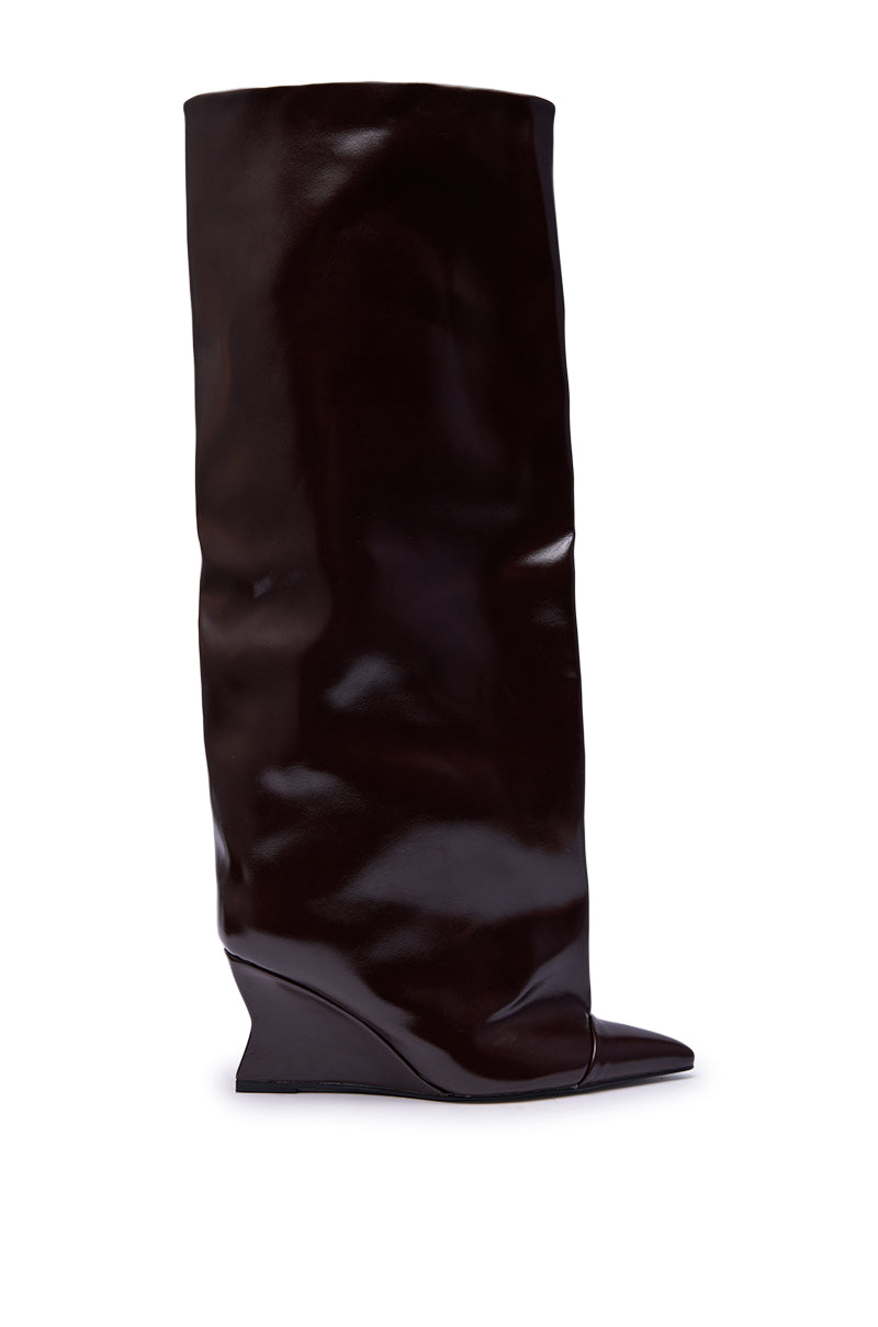 The AZALEA WANG KENYA BROWN KNEE HIGH WEDGE BOOT features glossy dark brown luxe faux leather, a slouchy shaft, pointed toe, and unique angled wedge heel for a stylish knee-high look.