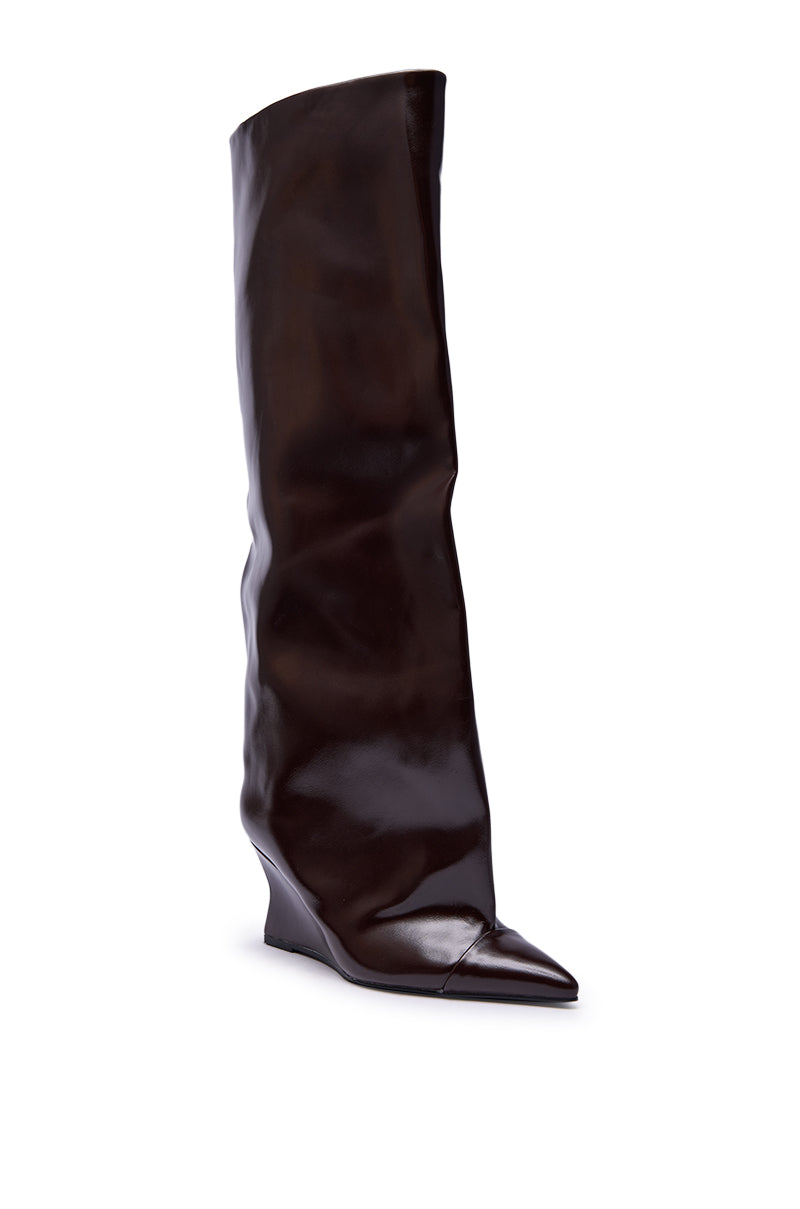 The AZALEA WANG KENYA Brown Knee High Wedge Boot features a tall, slouchy silhouette, pointed toe, and low sculpted wedge heel, shown here in brown on a white background.