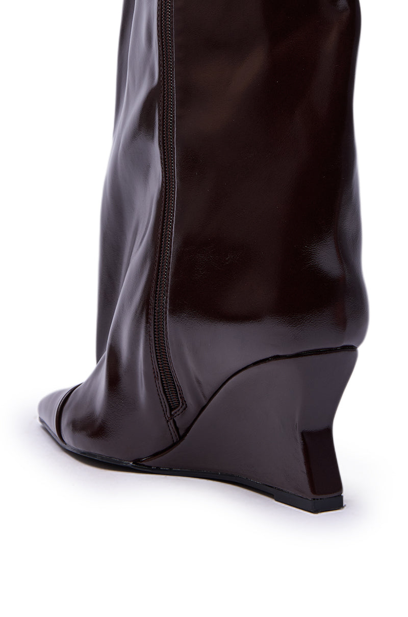 Close-up of the AZALEA WANG KENYA BROWN KNEE HIGH WEDGE BOOT, featuring shiny dark brown material and a side zipper, shown from a rear side angle against a white background.