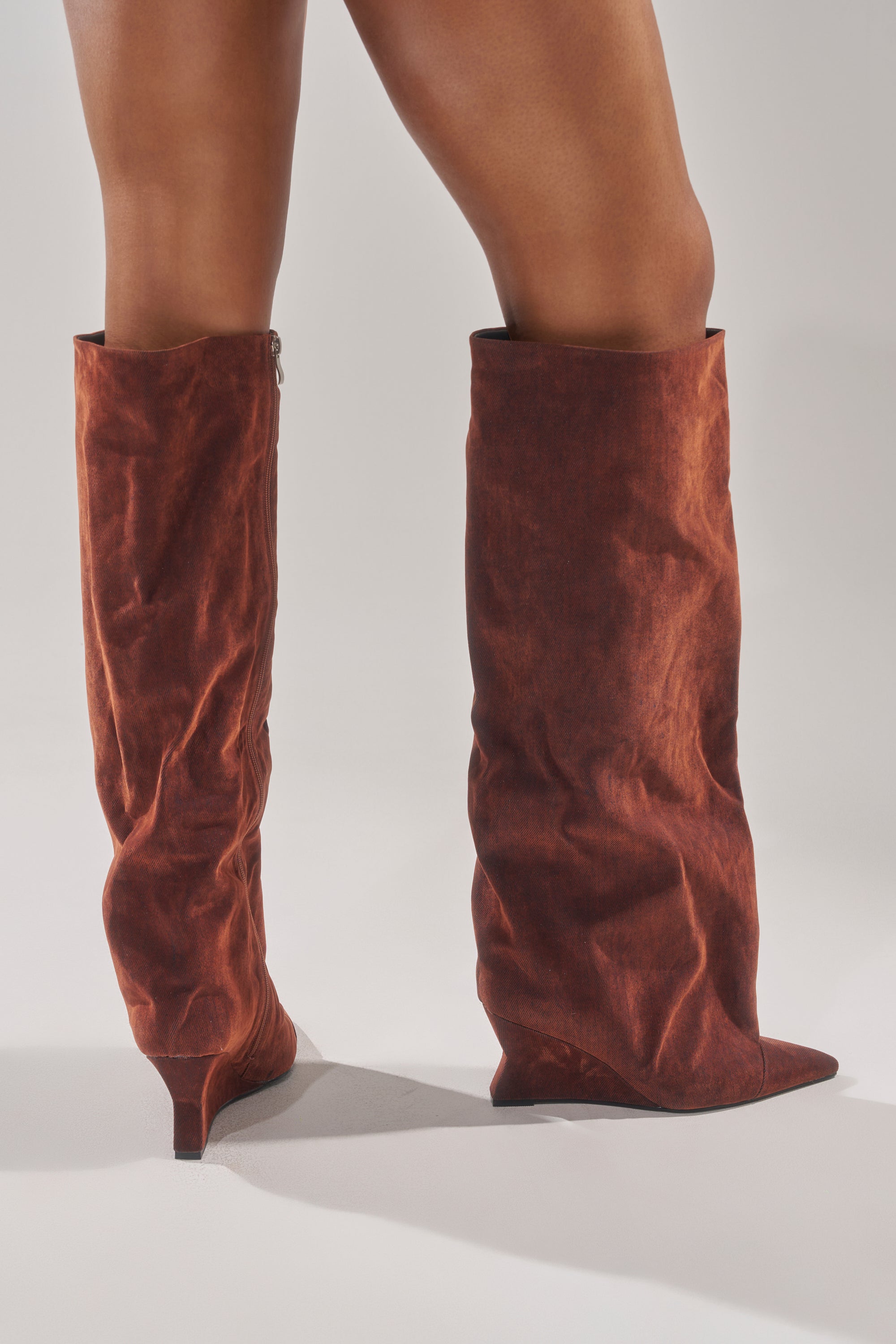 Someone is wearing the AZALEA WANG KENYA BURNT ORANGE VELVET KNEE HIGH WEDGE BOOT, standing against a plain light gray background.