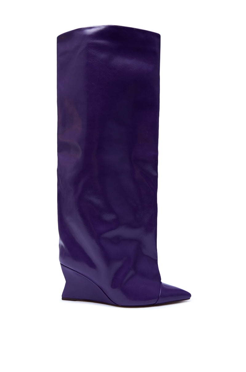 The AZALEA WANG KENYA PURPLE KNEE HIGH WEDGE BOOT is a slouchy, shiny purple faux leather boot with a pointed toe and low wedge heel.