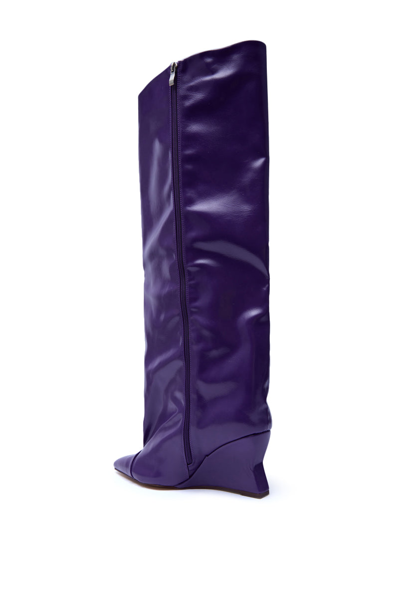 The AZALEA WANG KENYA PURPLE KNEE HIGH WEDGE BOOT features glossy purple faux leather, a pointed toe, side zipper, low wedge heel, and is displayed in side profile on a white background.