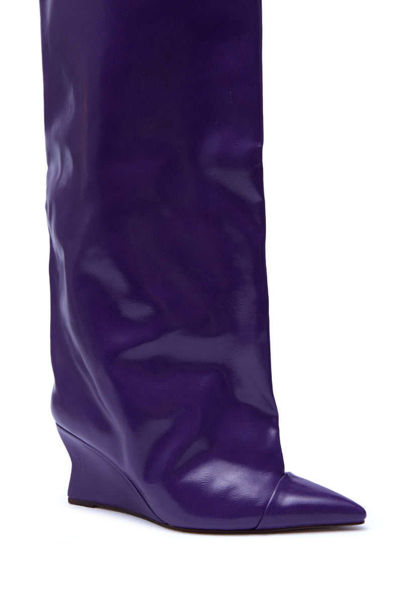 A close-up of the AZALEA WANG KENYA PURPLE KNEE HIGH WEDGE BOOT, showcasing its shiny purple finish, pointed toe, slouchy shaft, and seamless design without visible embellishments.
